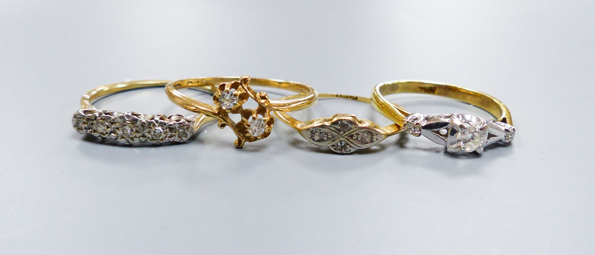 Three assorted 18ct and diamond set rings, including two stone crossover, gross 6.5 grams and a yellow metal and five stone illusion set diamond half hoop ring, gross 2.1 grams.